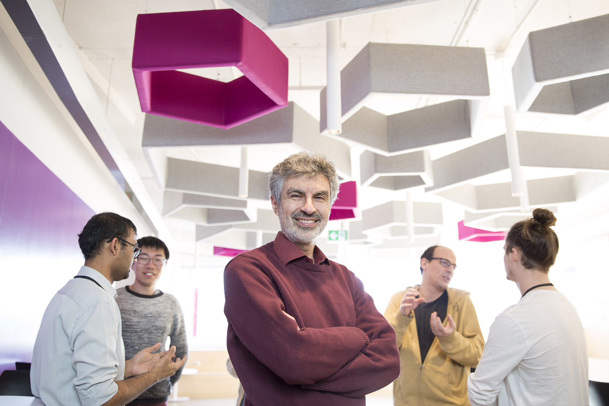 Yoshua Bengio standing in an indoor workspace in 2019