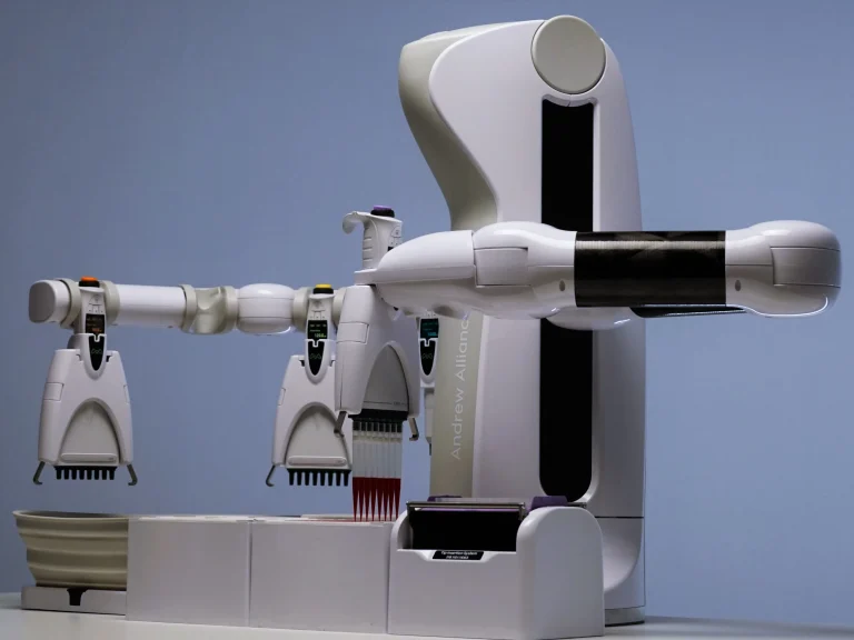 An Andrew+ liquid handling robot with several electronic pipettes above its work surface