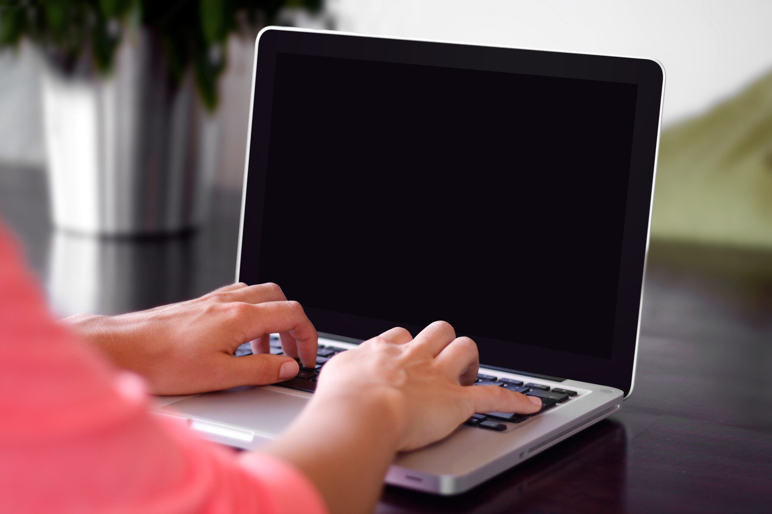 Hands typing on a laptop keyboard