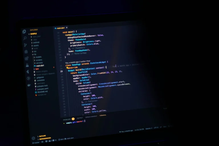 Illustrative photograph of a dark computer screen displaying Dart and Flutter code
