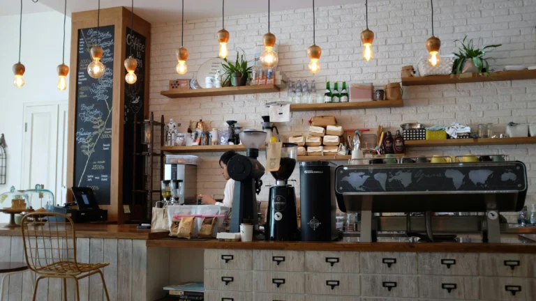 A coffee shop counter with espresso equipment and hanging lights