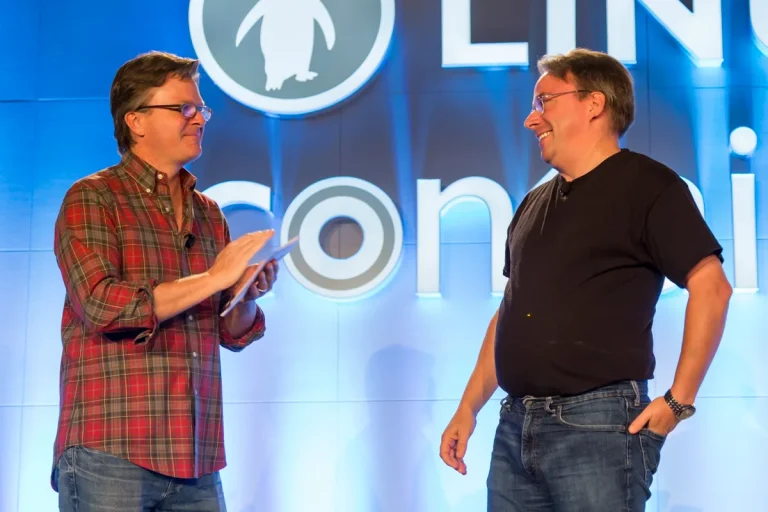 Archival photo of Linus Torvalds at right and Jim Zemlin on stage at LinuxCon North America in Toronto in 2016