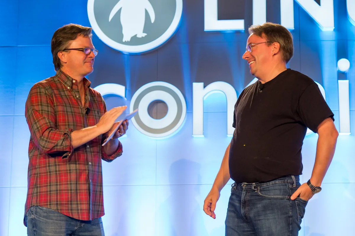 Archival photo of Linus Torvalds at right and Jim Zemlin on stage at LinuxCon North America in Toronto in 2016