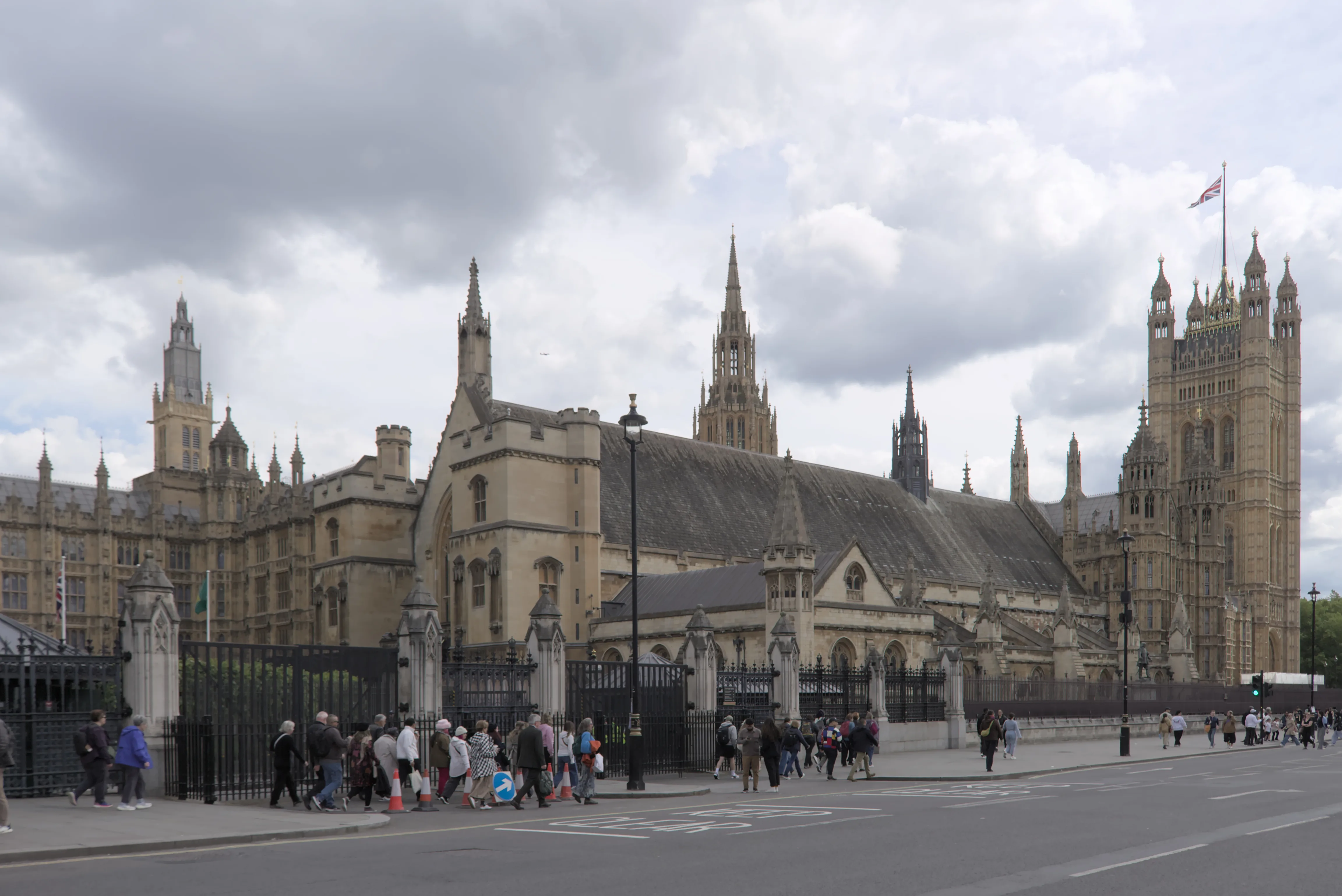 West facade of the Palace of Westminster with pedestrians on the pavement