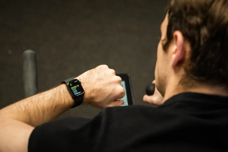 Contextual photo from July 2021 of a cyclist checking a smartwatch during an indoor workout