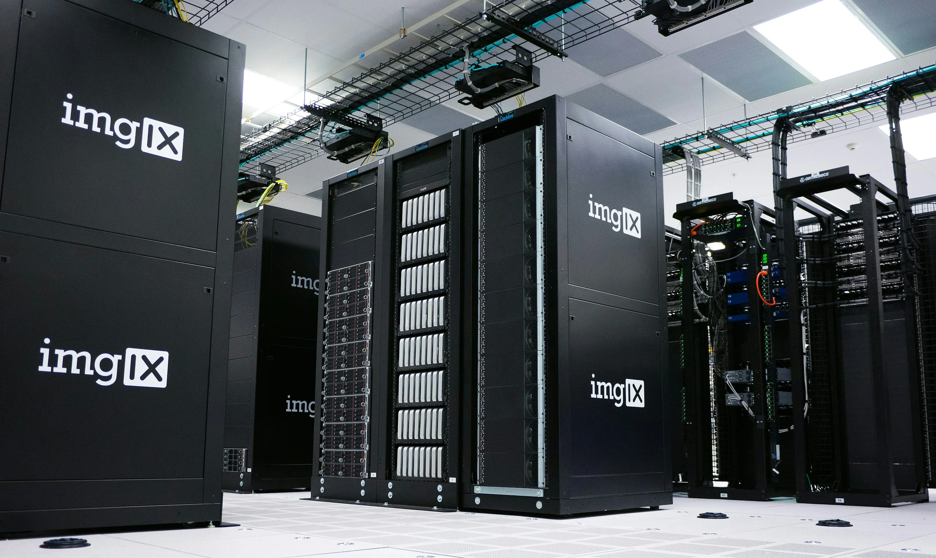 Rows of black server racks with imgix logos in a data center