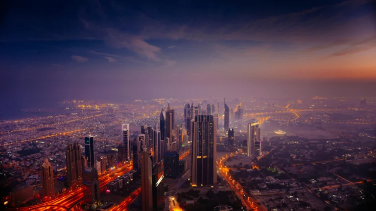 Dubai skyscrapers and illuminated roads beneath a hazy purple and orange sky