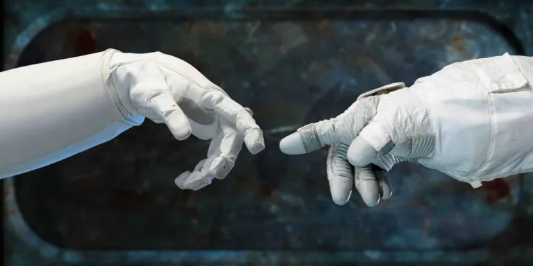 Archival NASA photograph of a Robonaut hand reaching toward a spacesuit glove