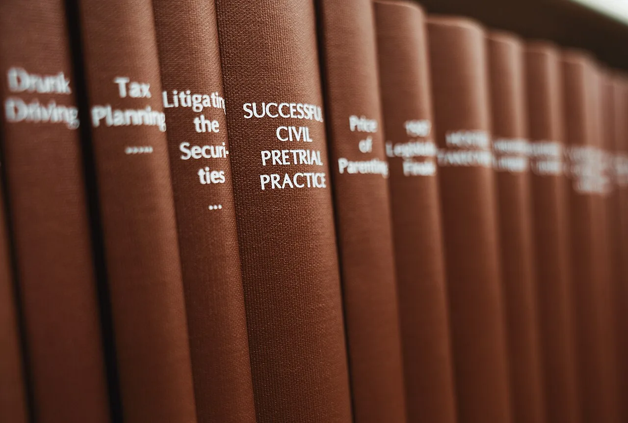 Brown legal volumes on a library shelf with a civil pretrial practice book in focus.