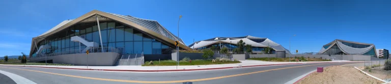 Google Bay View campus buildings with curved roofs beneath a blue sky