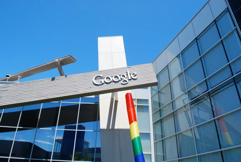 Google sign across glass campus buildings under a blue sky