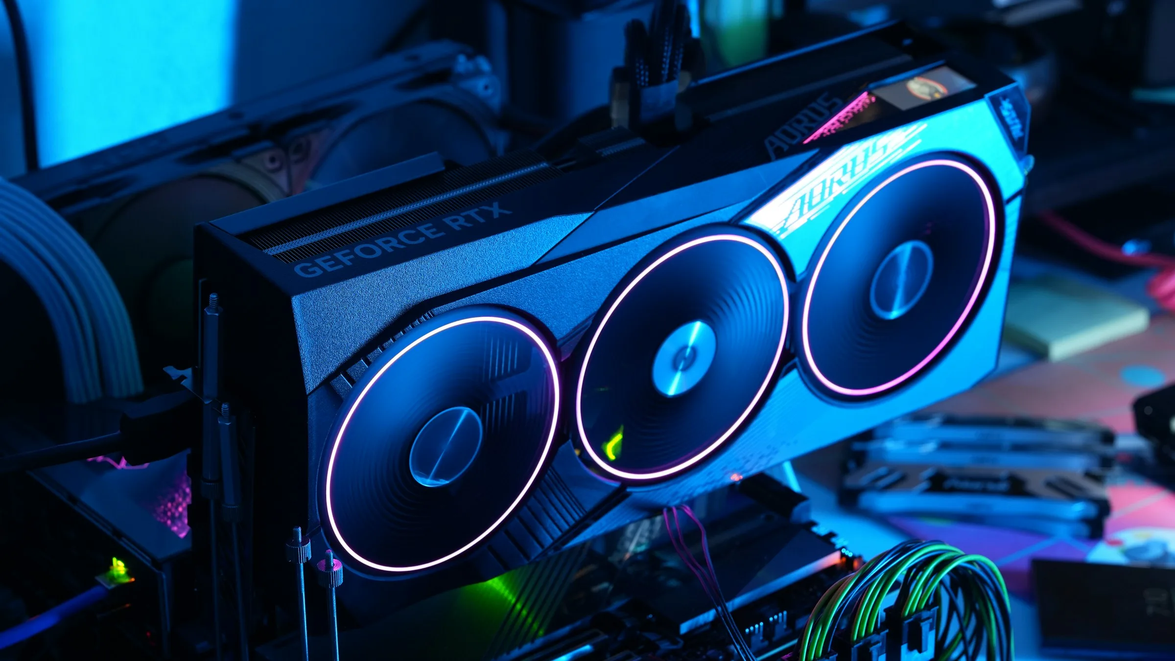 A GeForce RTX graphics card with three illuminated fans inside a computer