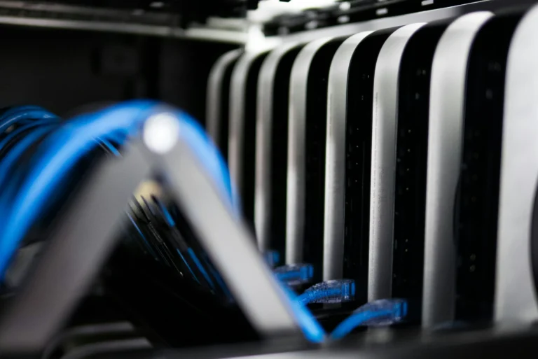 A row of compact computers connected by blue cables inside a rack