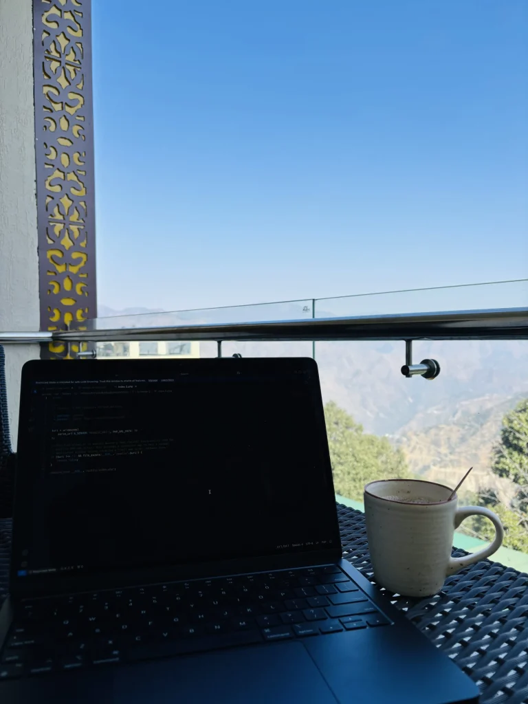 Laptop showing code beside a coffee mug on an outdoor table
