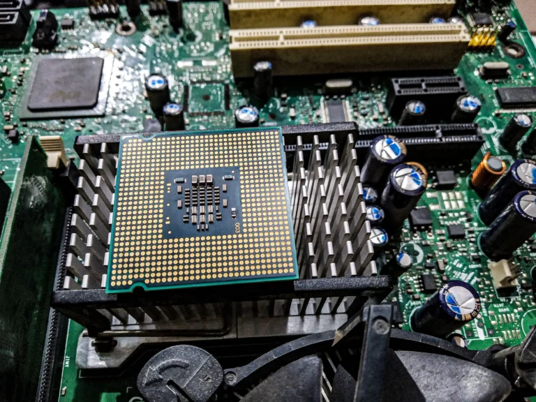 A processor rests on a heatsink above a green motherboard
