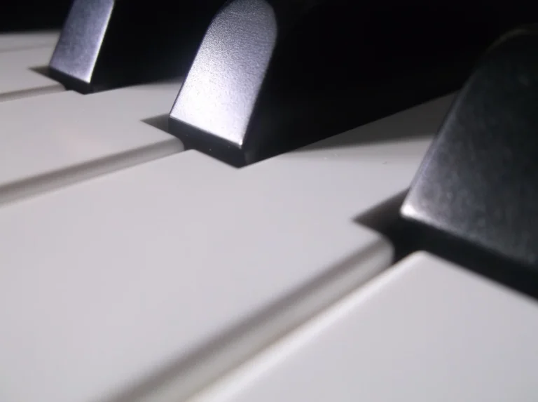 Close view of black and white piano keys with light falling across their surfaces