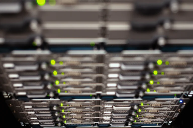 Rows of server drive bays with green indicator lights and shallow focus