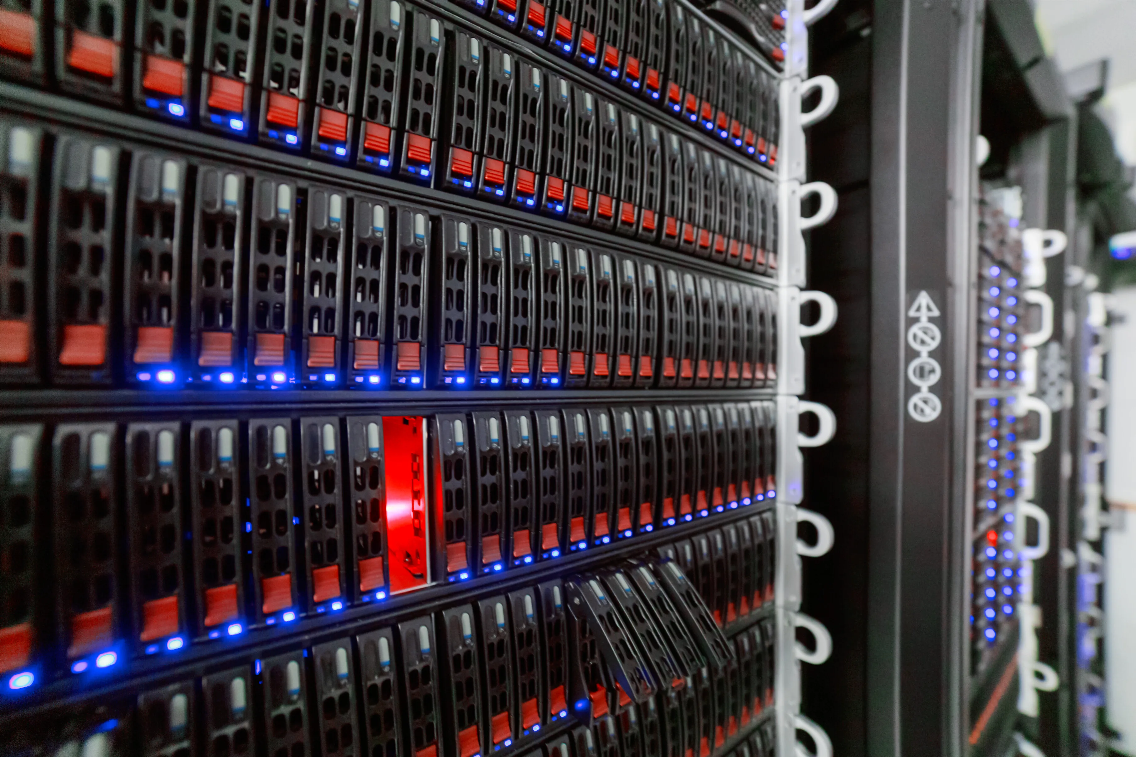 Rows of server drive bays with red latches and blue indicator lights