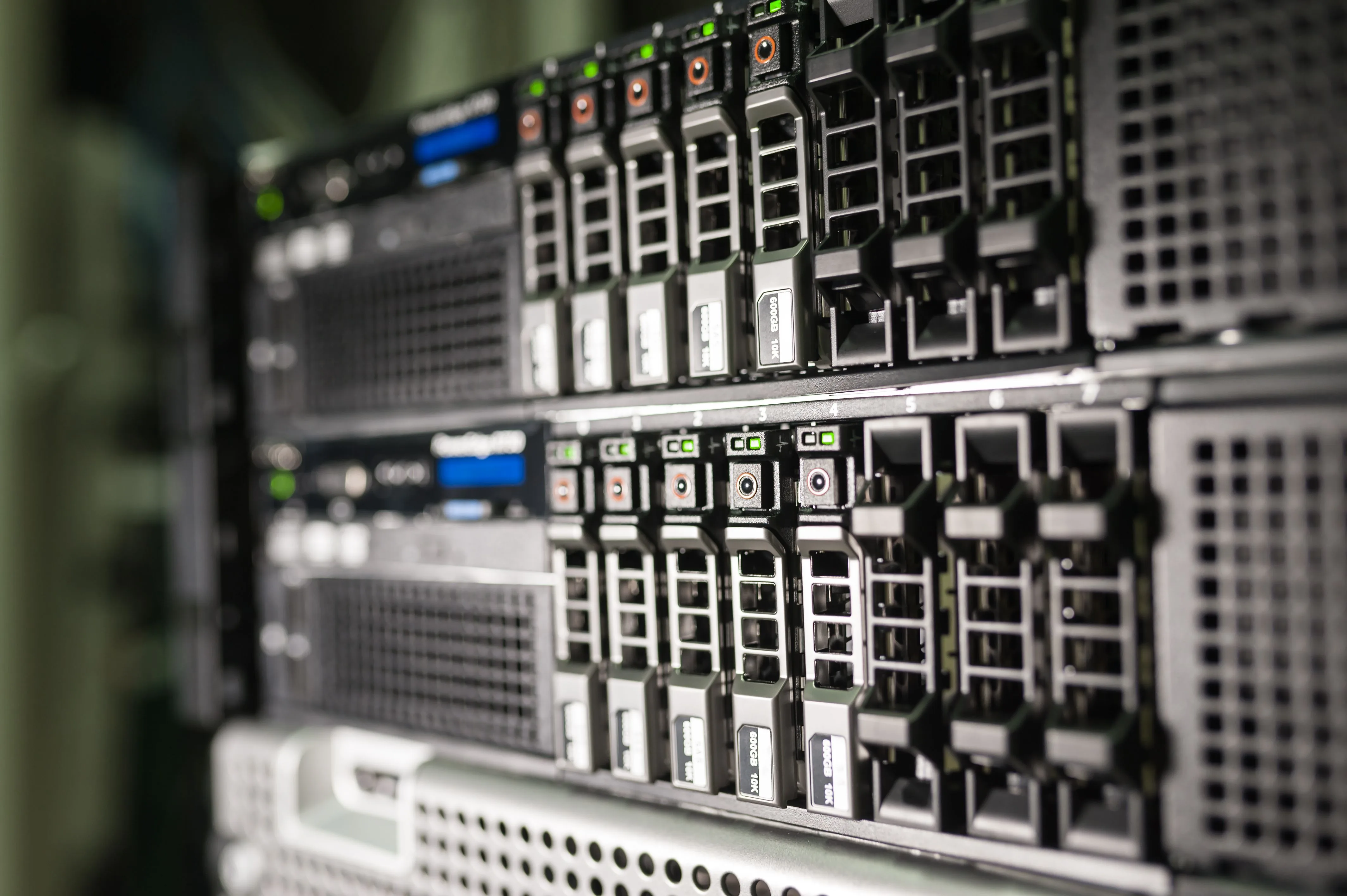 Rows of server drive bays with green indicator lights and blue display panels