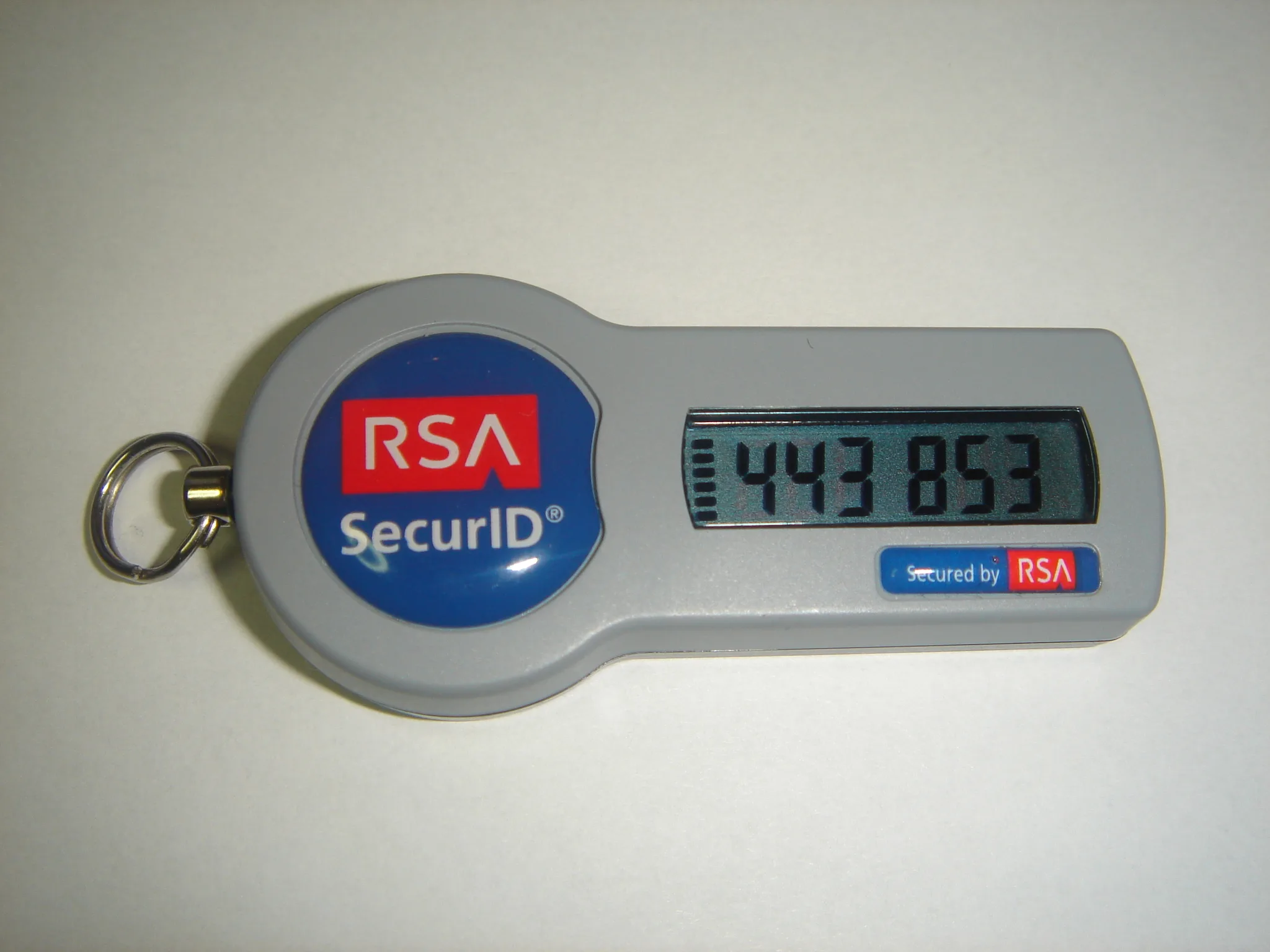 Gray RSA SecurID hardware token with a digital display on a light surface