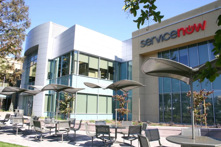 ServiceNow name on an office building beside outdoor tables in Santa Clara