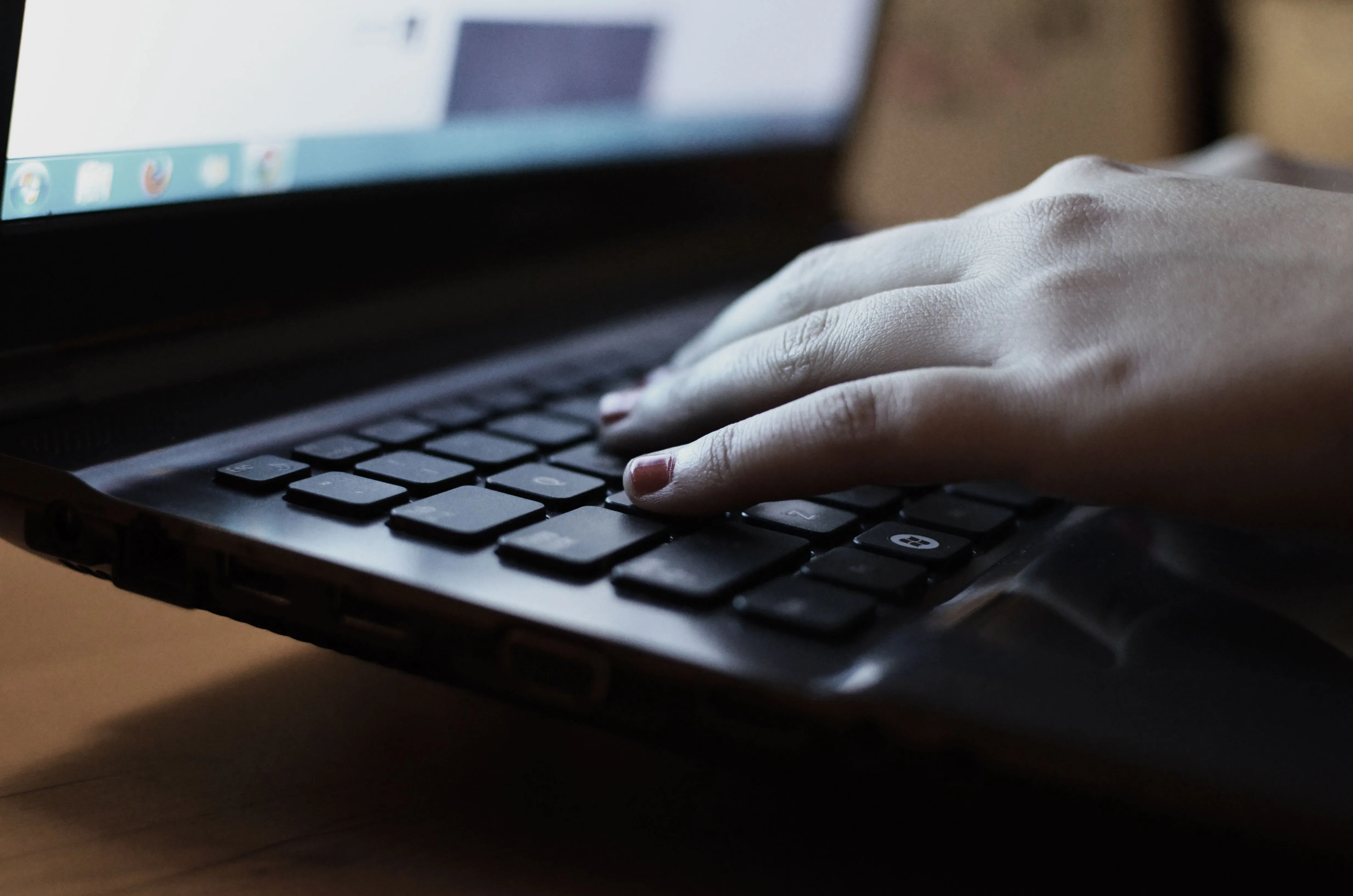 Hands typing on a black laptop keyboard