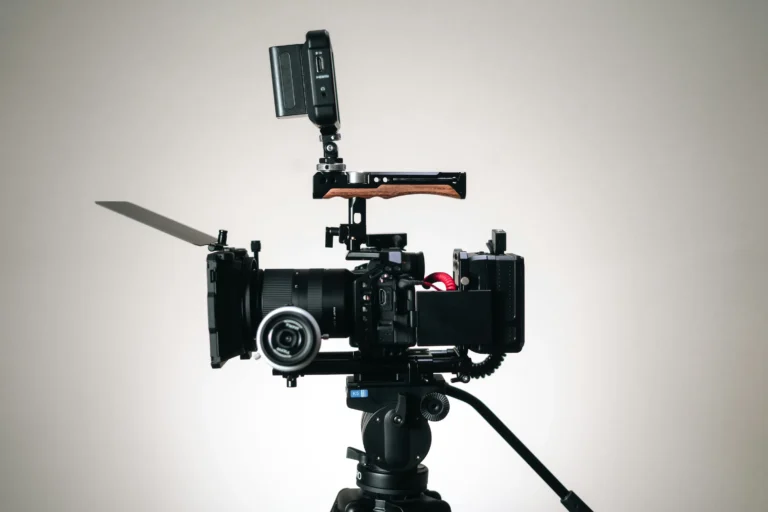 A professional video camera rig mounted on a tripod against a pale wall