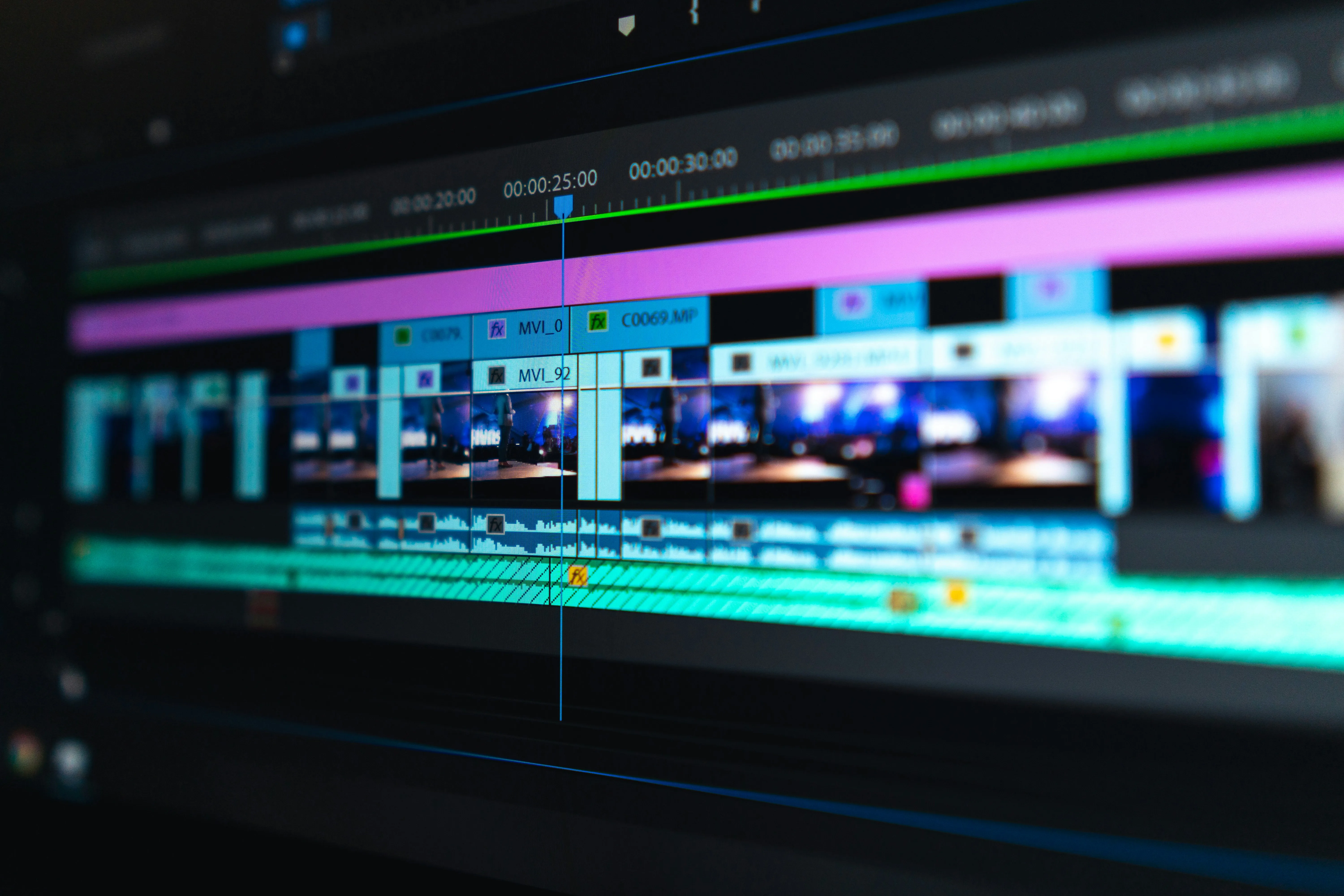Video editing timeline with blue and purple clips on a dark screen