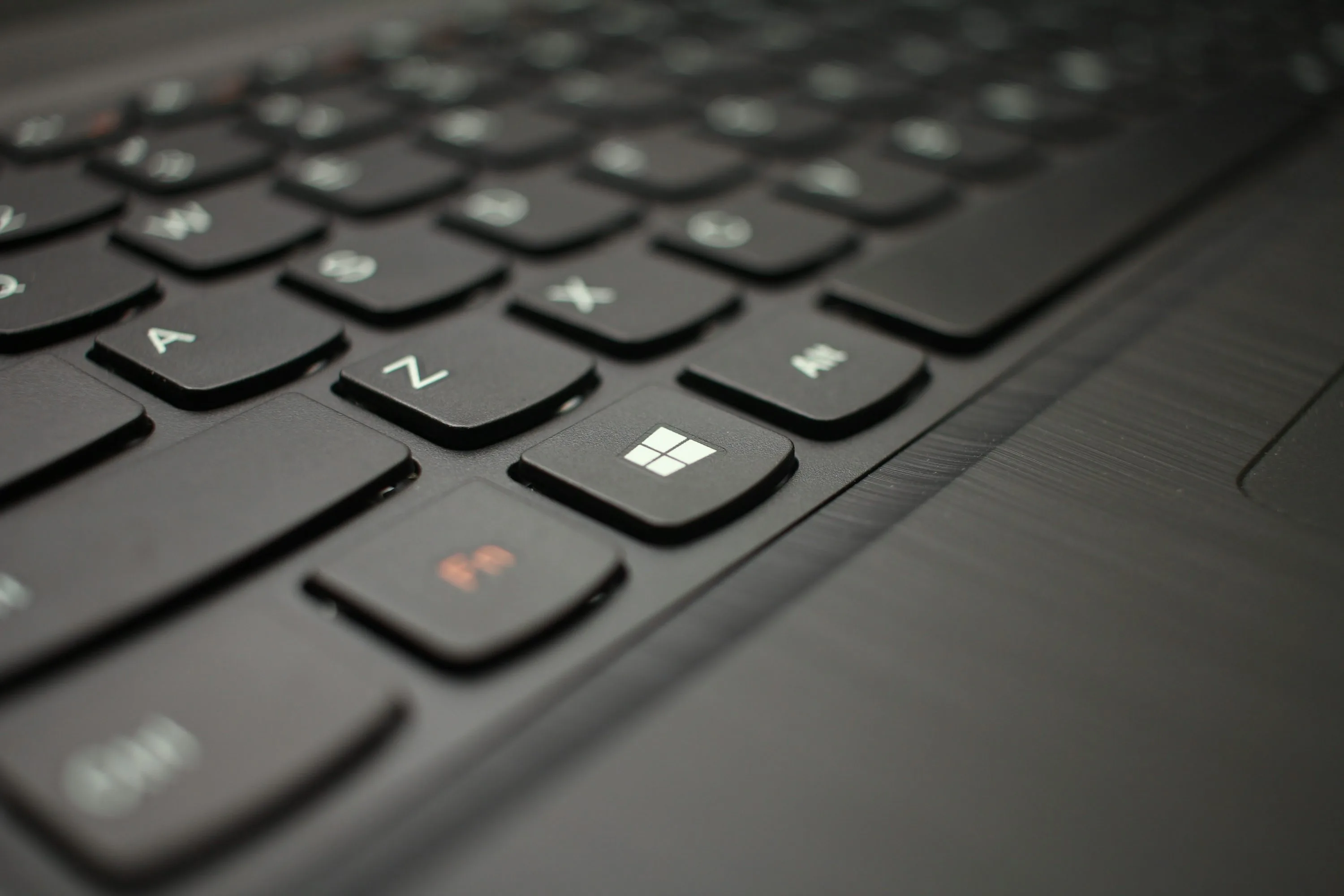 A close view of the Windows key on a black laptop keyboard