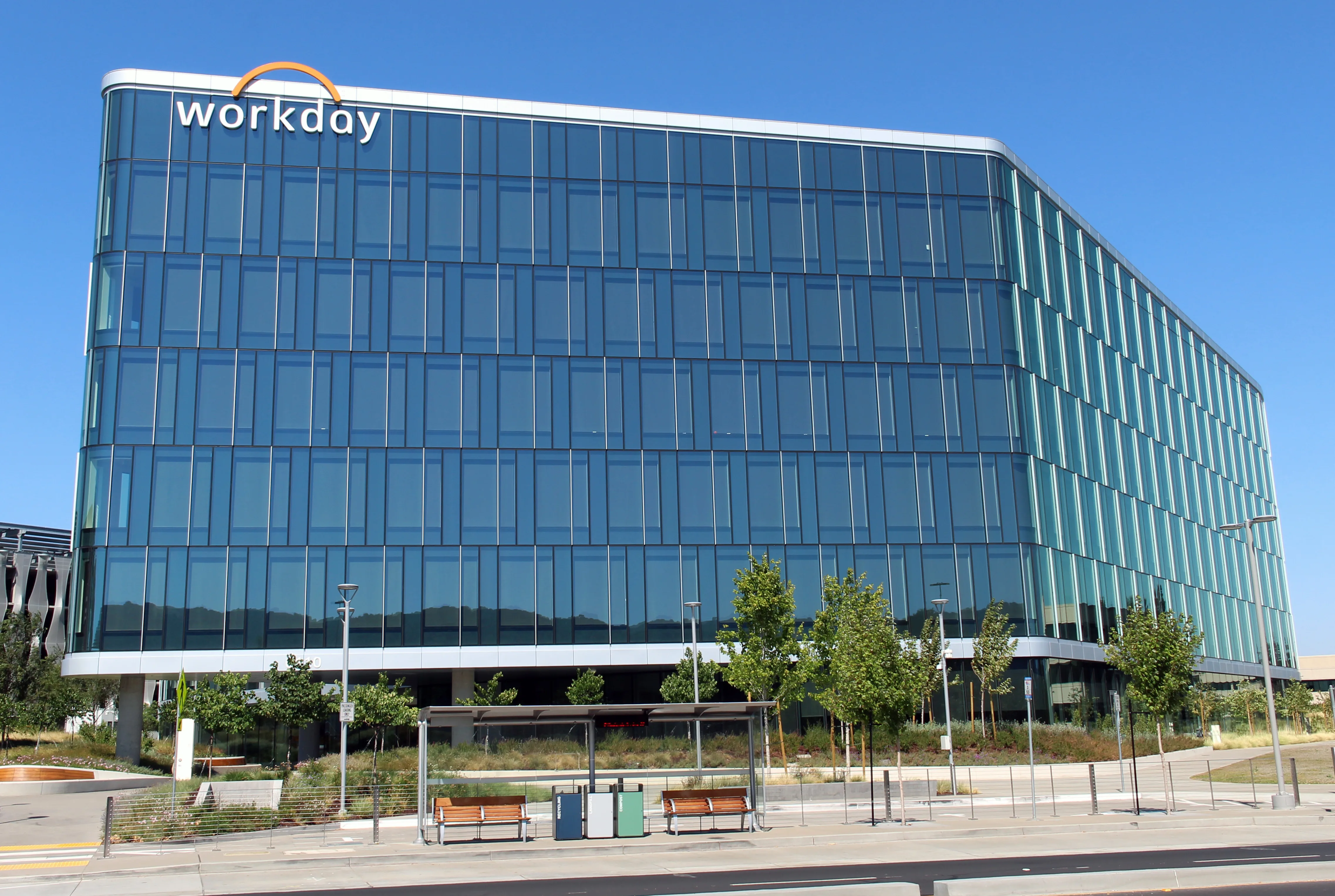 Workday lettering on a glass office building beneath a clear blue sky in Pleasanton.